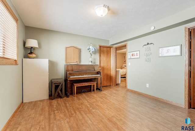 living area featuring a textured ceiling and light hardwood / wood-style flooring