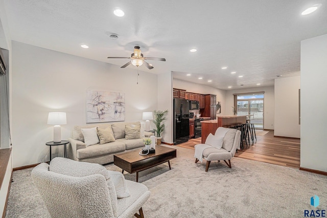 living room featuring ceiling fan and light hardwood / wood-style flooring