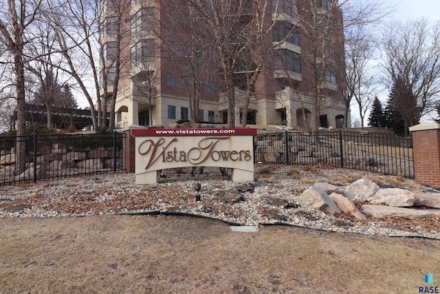 community / neighborhood sign featuring fence