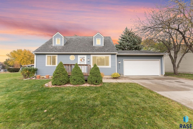 cape cod home with a wooden deck, a garage, and a lawn