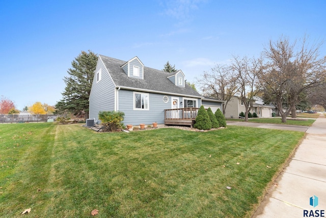 view of front of property with a deck, cooling unit, a shingled roof, and a front lawn