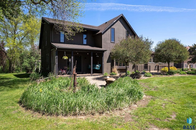 rear view of house featuring a patio and a lawn