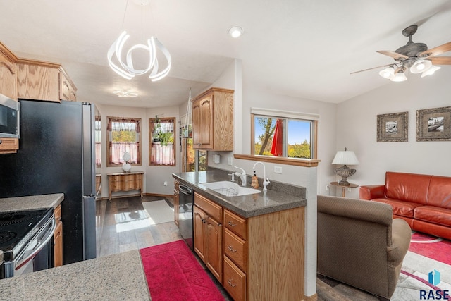 kitchen with light wood-type flooring, hanging light fixtures, stainless steel appliances, sink, and vaulted ceiling