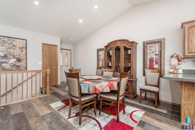 dining room featuring dark wood-type flooring and vaulted ceiling