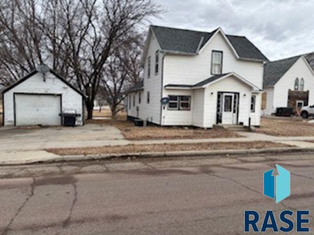 view of front of property with a garage, driveway, central AC, and an outdoor structure