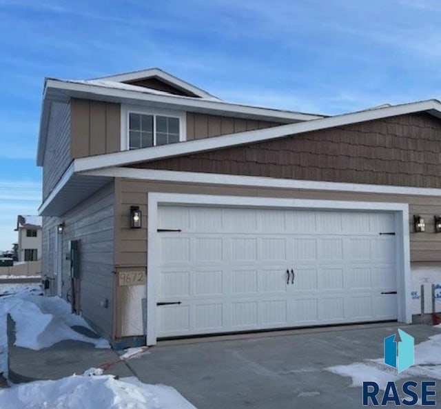 snow covered property featuring a garage