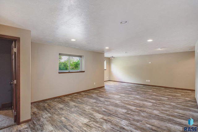 unfurnished room featuring a textured ceiling and hardwood / wood-style flooring