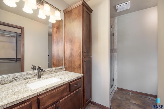 bathroom featuring a chandelier, vanity, and walk in shower