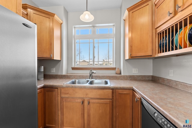 kitchen featuring decorative light fixtures, sink, black dishwasher, and stainless steel fridge