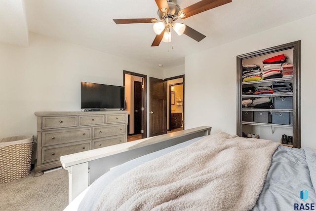 bedroom with a closet, connected bathroom, ceiling fan, a walk in closet, and light colored carpet