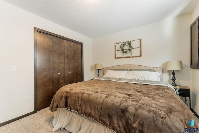 bedroom with a closet, carpet floors, and a textured ceiling