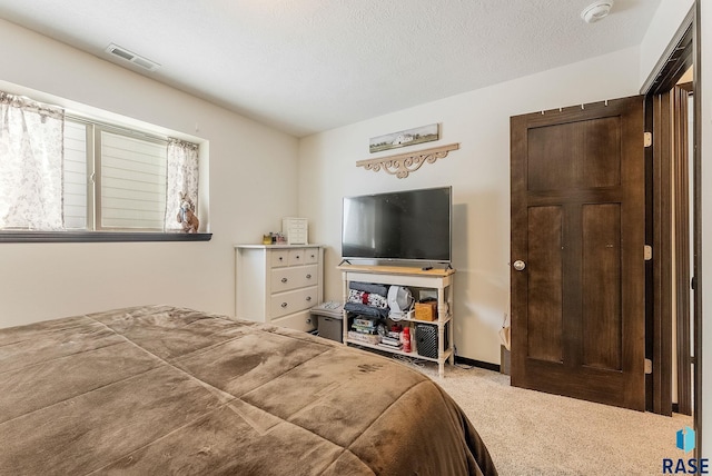 carpeted bedroom featuring a textured ceiling