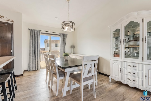 dining area featuring light hardwood / wood-style flooring and vaulted ceiling