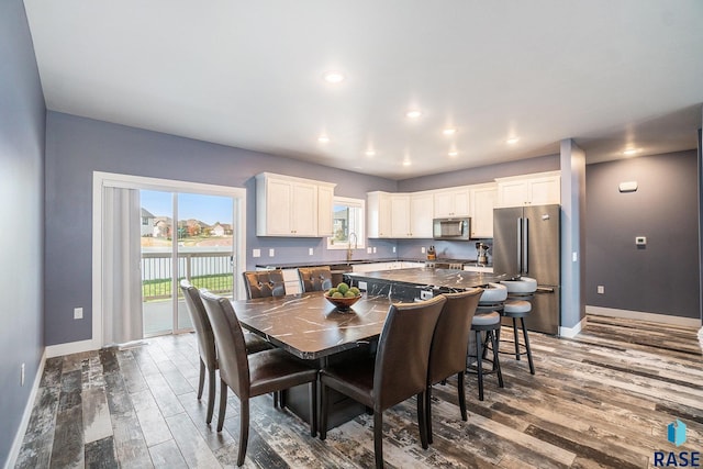 dining area featuring sink, a water view, and dark hardwood / wood-style floors