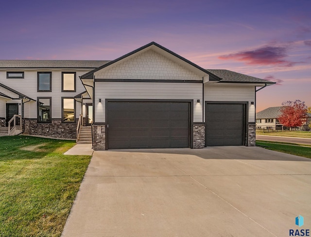 view of front of property featuring a garage and a lawn