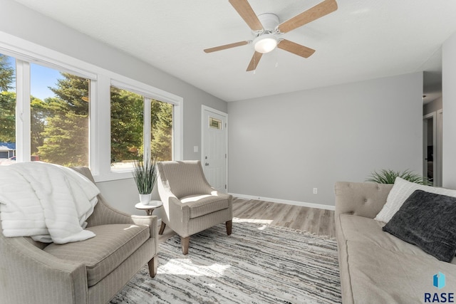 sitting room with light wood-type flooring and ceiling fan