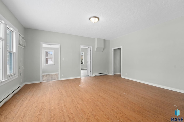 unfurnished living room with a textured ceiling, light hardwood / wood-style floors, and baseboard heating