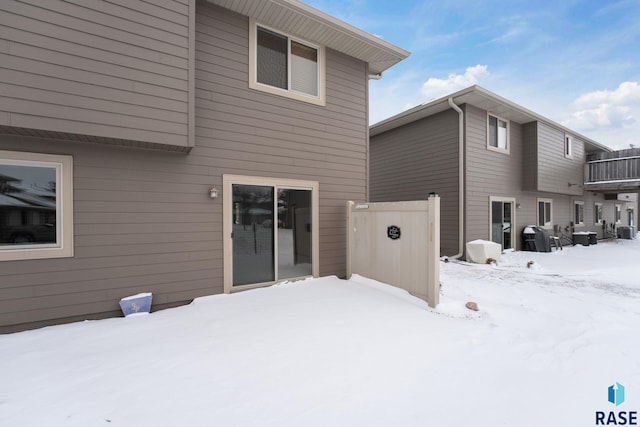 view of snow covered back of property