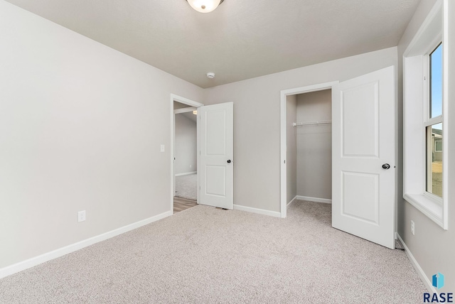 unfurnished bedroom with a closet and light colored carpet