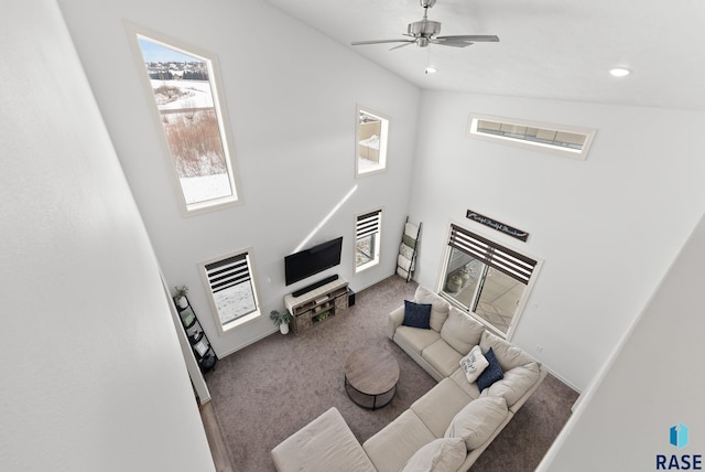 carpeted living room with a high ceiling and ceiling fan