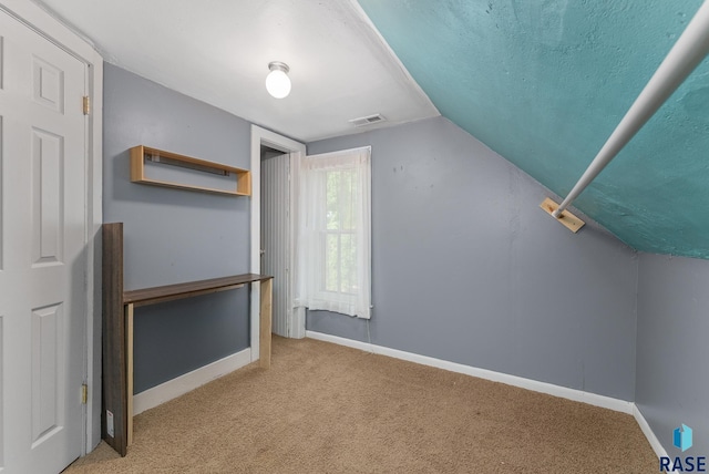 bonus room with lofted ceiling, a textured ceiling, and light colored carpet