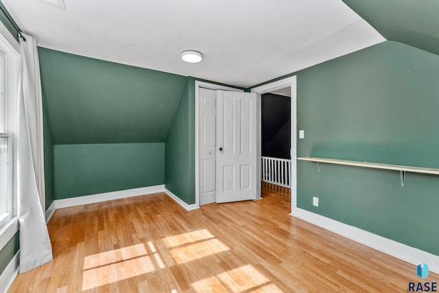 additional living space featuring vaulted ceiling and hardwood / wood-style floors