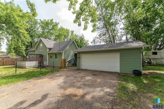 view of front of house with a front yard, a garage, and an outdoor structure