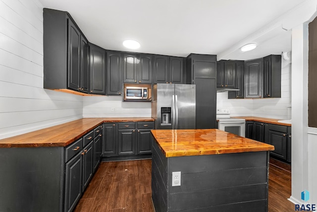 kitchen with wood counters, stainless steel appliances, dark hardwood / wood-style floors, and a center island