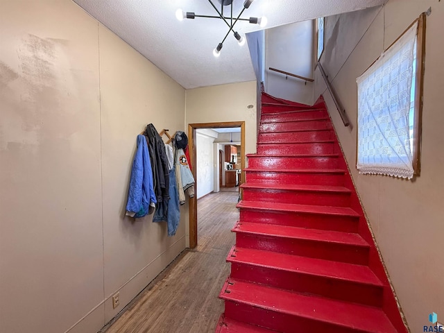 stairway featuring a textured ceiling and hardwood / wood-style floors