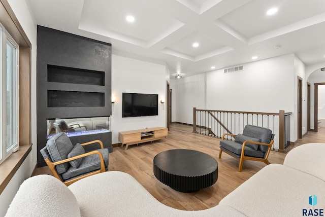 living room featuring light wood-type flooring, beamed ceiling, and coffered ceiling