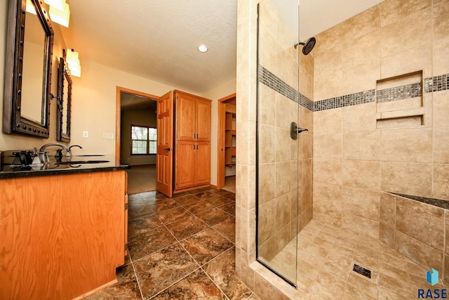 bathroom featuring vanity and tiled shower