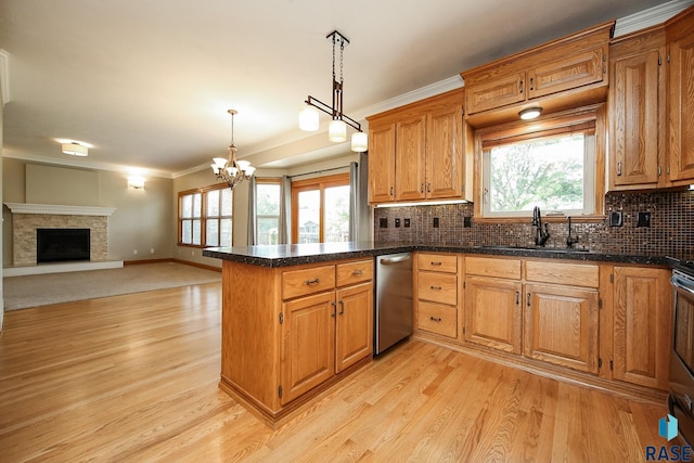 kitchen with sink, decorative light fixtures, kitchen peninsula, crown molding, and light hardwood / wood-style flooring