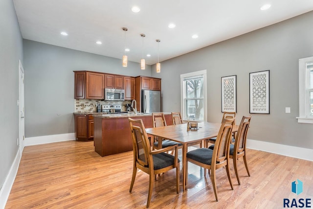 dining space featuring baseboards, recessed lighting, and light wood-type flooring