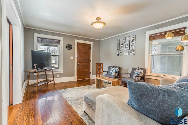 living area with crown molding, dark wood-type flooring, and baseboards