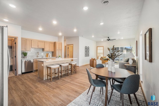 dining room featuring baseboards, a ceiling fan, light wood-style flooring, and recessed lighting