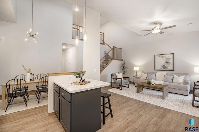 kitchen featuring light wood-style floors, open floor plan, and decorative light fixtures