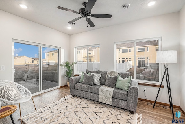 living area with ceiling fan, baseboards, wood finished floors, and recessed lighting