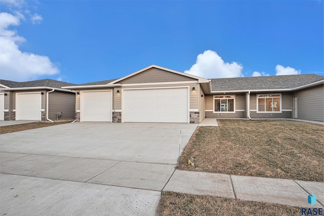 ranch-style house with concrete driveway, stone siding, an attached garage, and a front yard