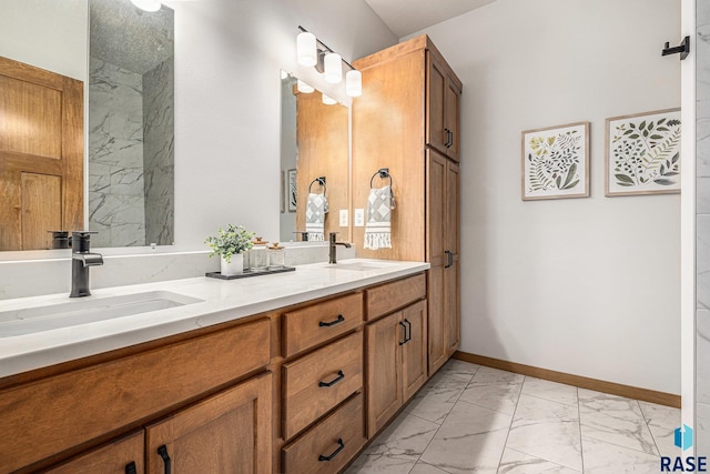 full bathroom with marble finish floor, double vanity, a sink, and baseboards