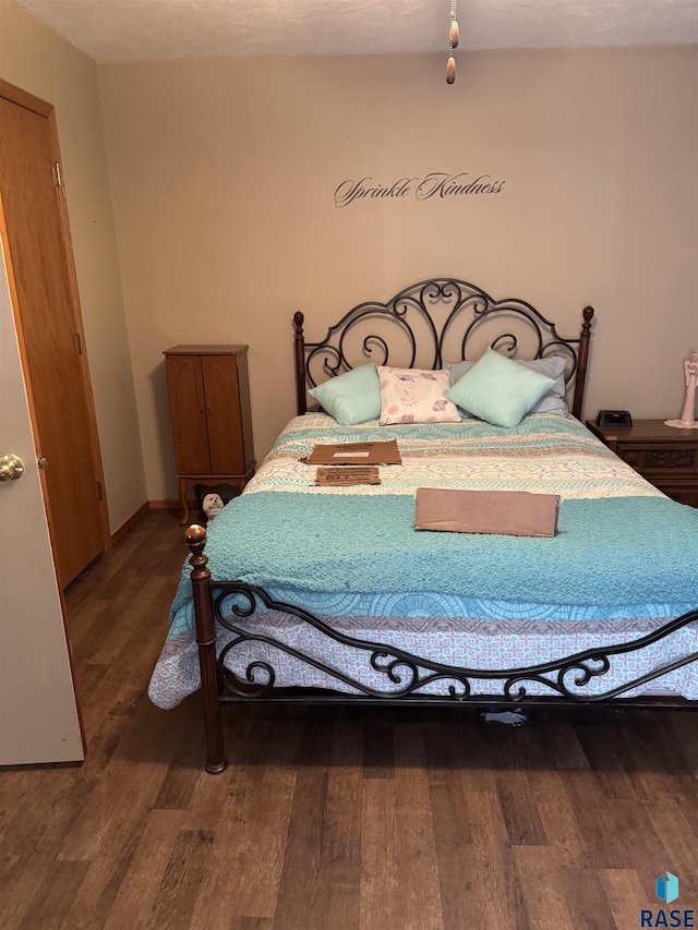 bedroom featuring baseboards and wood finished floors