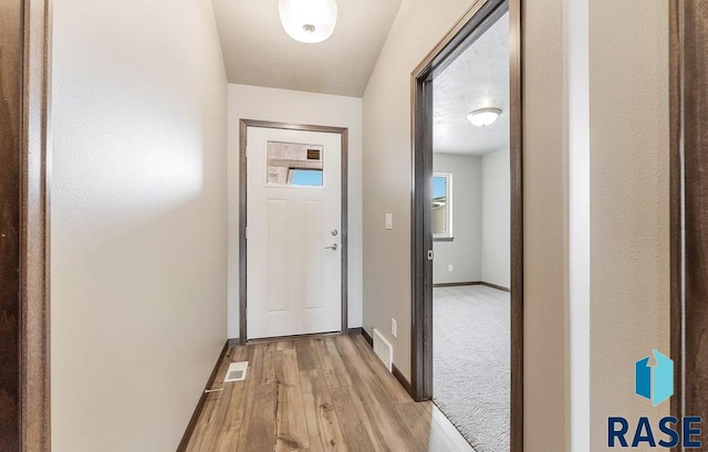 entryway featuring light wood-style flooring, visible vents, and baseboards