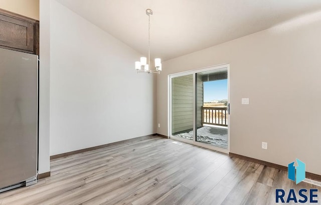 unfurnished dining area with light wood finished floors, baseboards, vaulted ceiling, and a notable chandelier