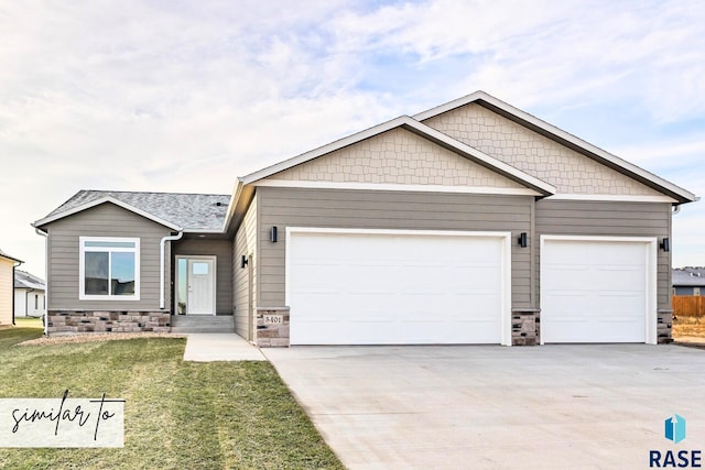 view of front of house featuring a garage, driveway, and a front lawn