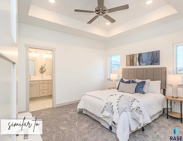 bedroom featuring light carpet, baseboards, connected bathroom, a tray ceiling, and recessed lighting