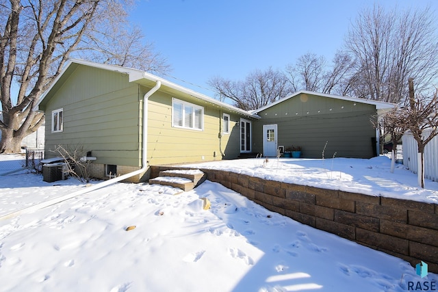 view of front of home featuring central AC and fence