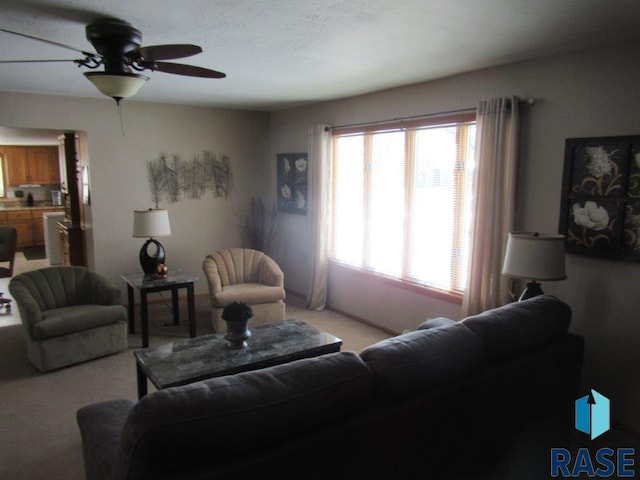 living area featuring a ceiling fan and light colored carpet