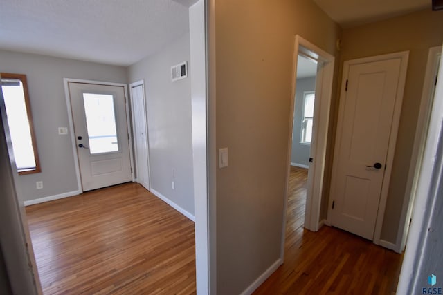 entrance foyer with visible vents, baseboards, and wood finished floors