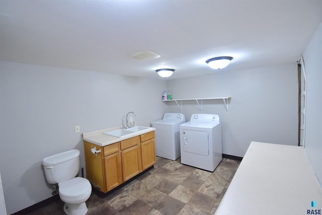 laundry room with laundry area, baseboards, independent washer and dryer, and a sink