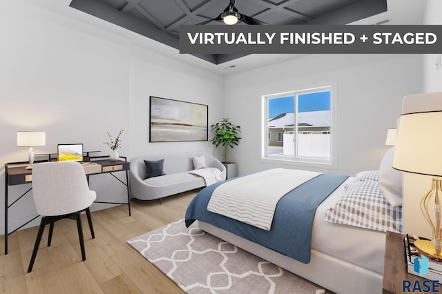 bedroom with light wood-type flooring and coffered ceiling