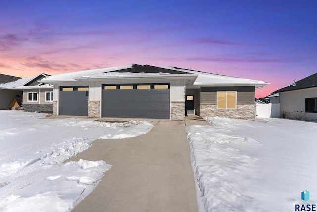 prairie-style home with stone siding, board and batten siding, and an attached garage